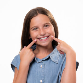 Free Smile Assessment, Patient smiling pointing at her smile